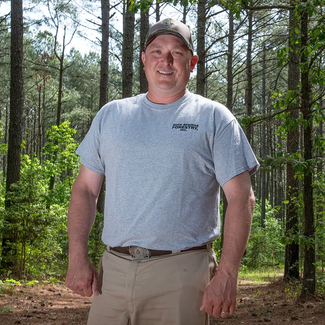Matthew standing in a wooded area